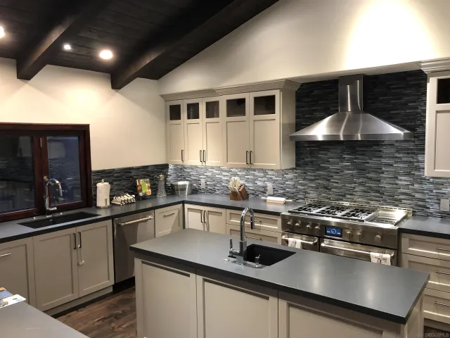 a kitchen with stainless steel appliances granite countertop a sink a stove and cabinets