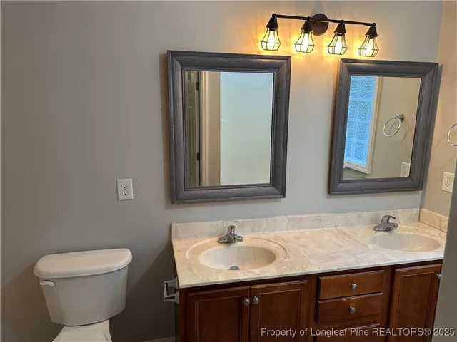 a bathroom with a sink mirror and toilet