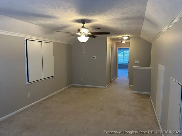 en empty room with windows and chandelier fan