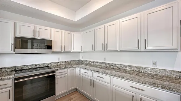 a bathroom with a granite countertop sink a toilet and a mirror