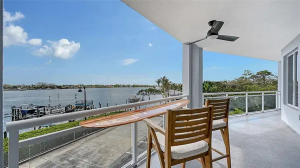 a view of a hallway with wooden floor and a bathroom