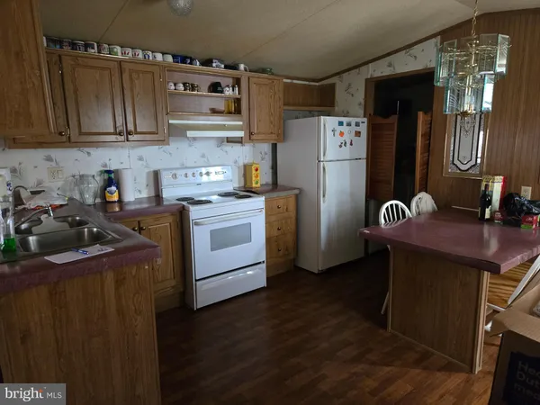a kitchen with stainless steel appliances a refrigerator a sink and wooden cabinets