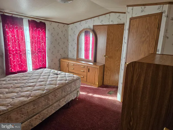 a bedroom with a bed closet and mirror