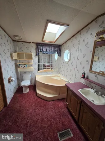 a spacious bathroom with a sink a toilet and a mirror