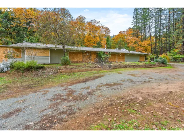 an aerial view of a house with a yard and a large tree