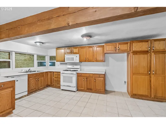 a large kitchen with stainless steel appliances kitchen island granite countertop a large counter top and a stove