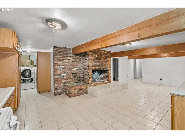 a utility room with dryer washer and a view of kitchen
