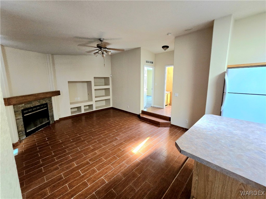 4149 Carrizo Road Golden Valley, AZ 86413 - Photo 23 of 47 an empty room with wooden floor fireplace and windows