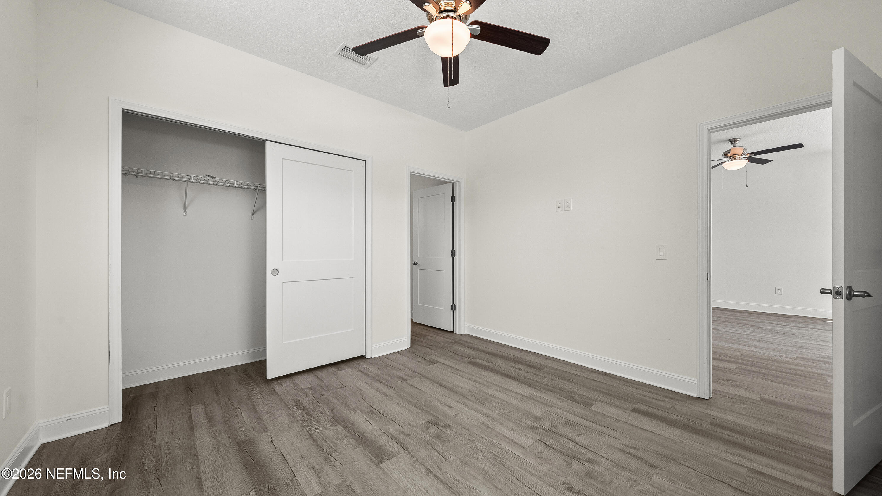 80 Seaside Capers Road St. Augustine, FL 32084 - Photo 13 of 44 an empty room with wooden floor ceiling fan and windows