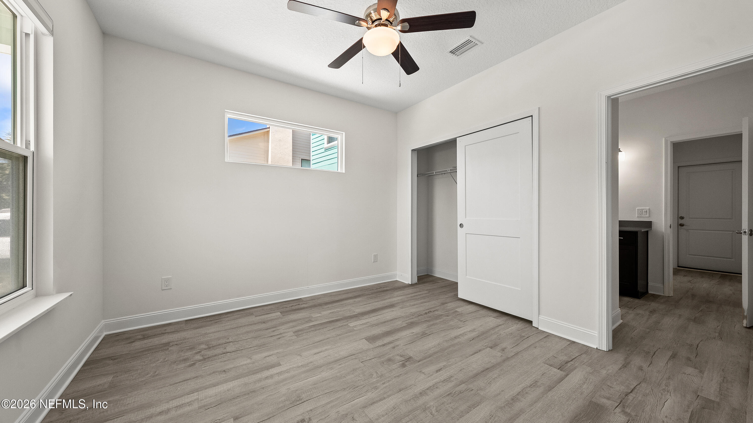 80 Seaside Capers Road St. Augustine, FL 32084 - Photo 14 of 44 a view of an empty room with wooden floor and a window
