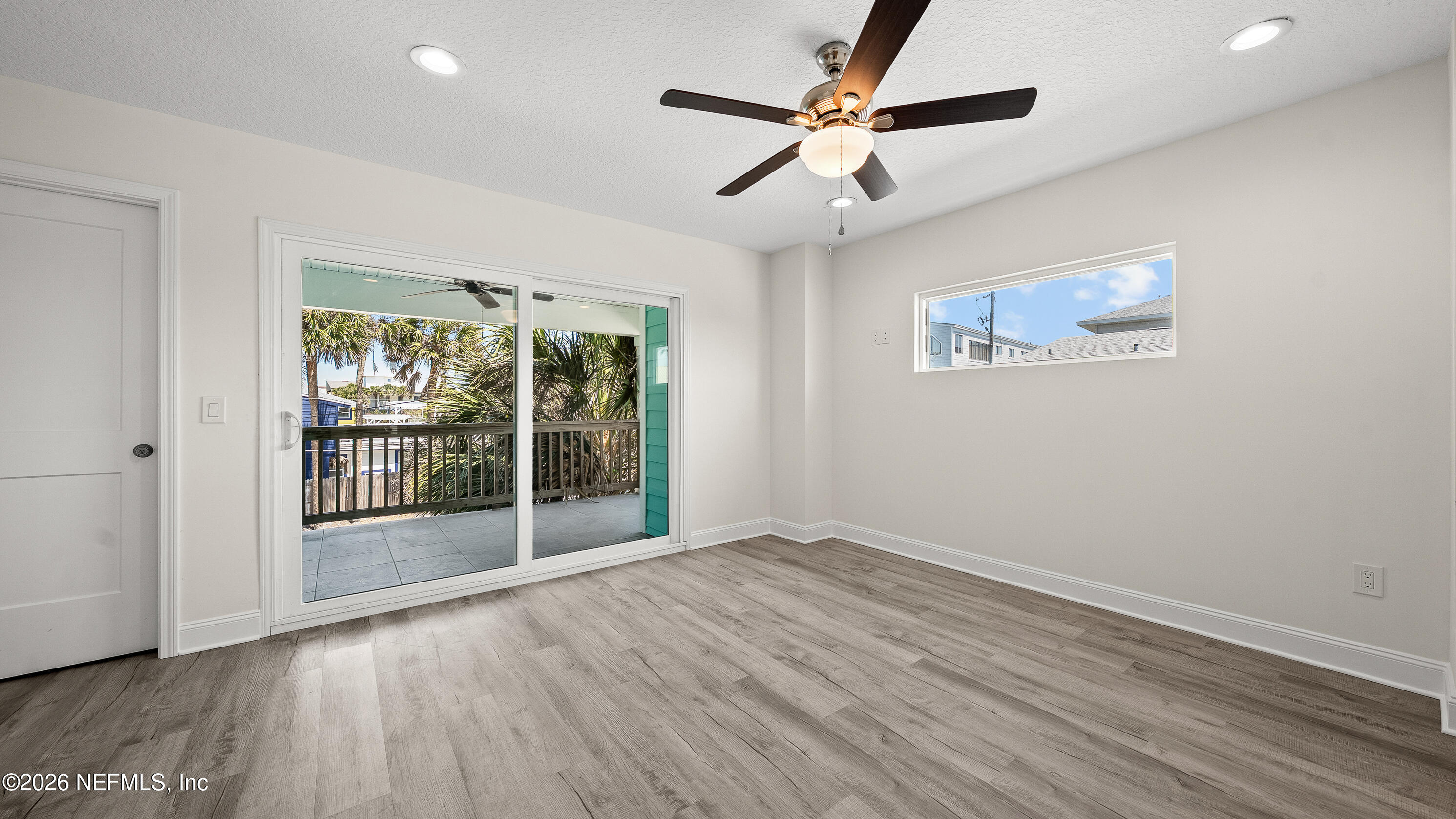 80 Seaside Capers Road St. Augustine, FL 32084 - Photo 19 of 44 an empty room with wooden floor fan and windows