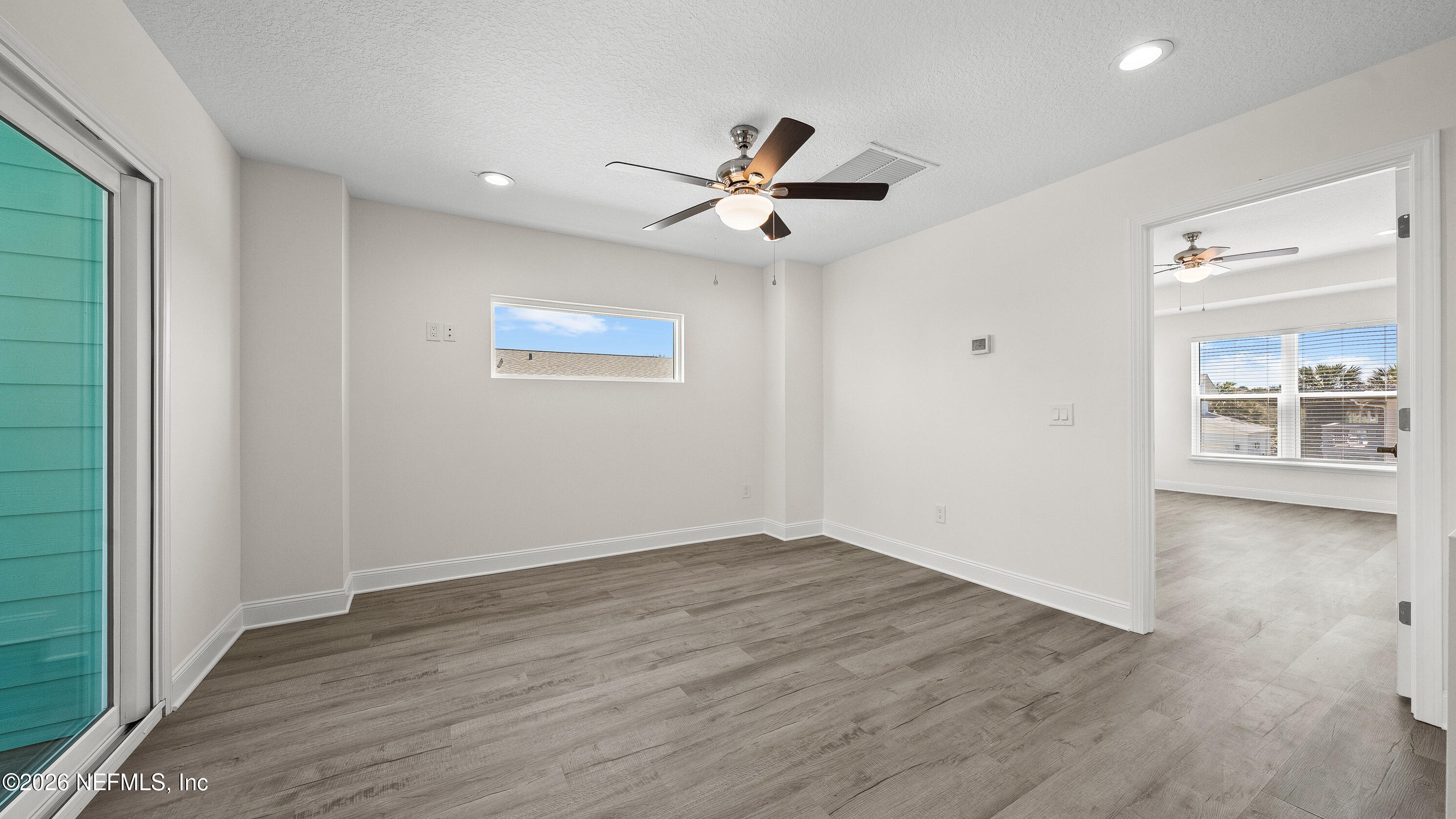 80 Seaside Capers Road St. Augustine, FL 32084 - Photo 20 of 44 an empty room with wooden floor a ceiling fan and windows