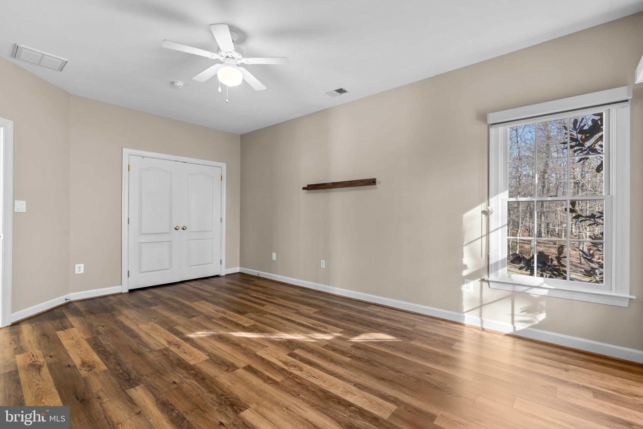 3091 Emerald Valley Road Ellicott City, MD 21042 - Photo 54 of 95 a view of an empty room with a window and wooden floor