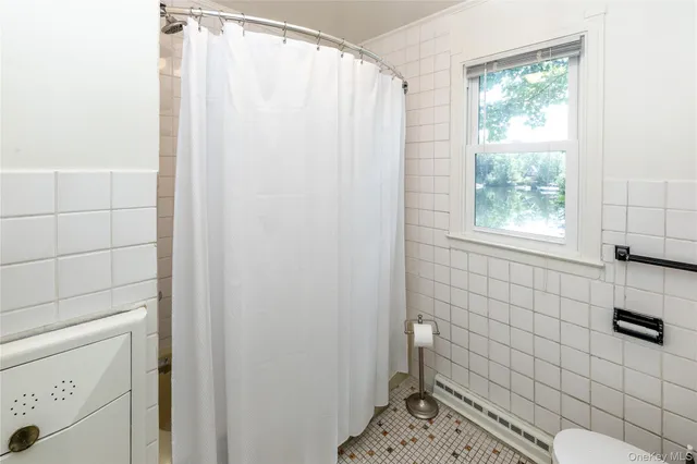 a living room with furniture a flat screen tv and a window