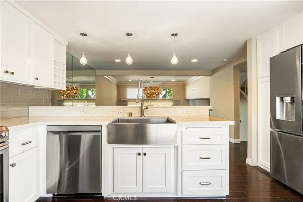 a kitchen with kitchen island a counter top space a sink appliances and cabinets