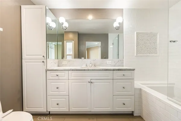 a bathroom with a sink a toilet and a mirror
