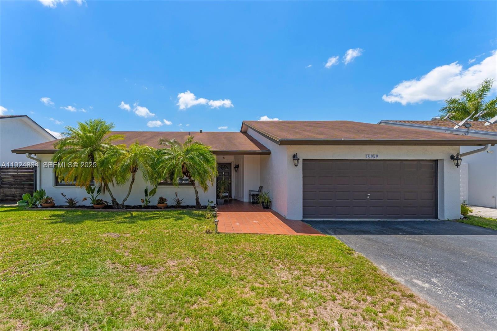10020 Southwest 145th Place Miami, FL 33186 - Photo 1 of 35 a front view of house with yard and garage