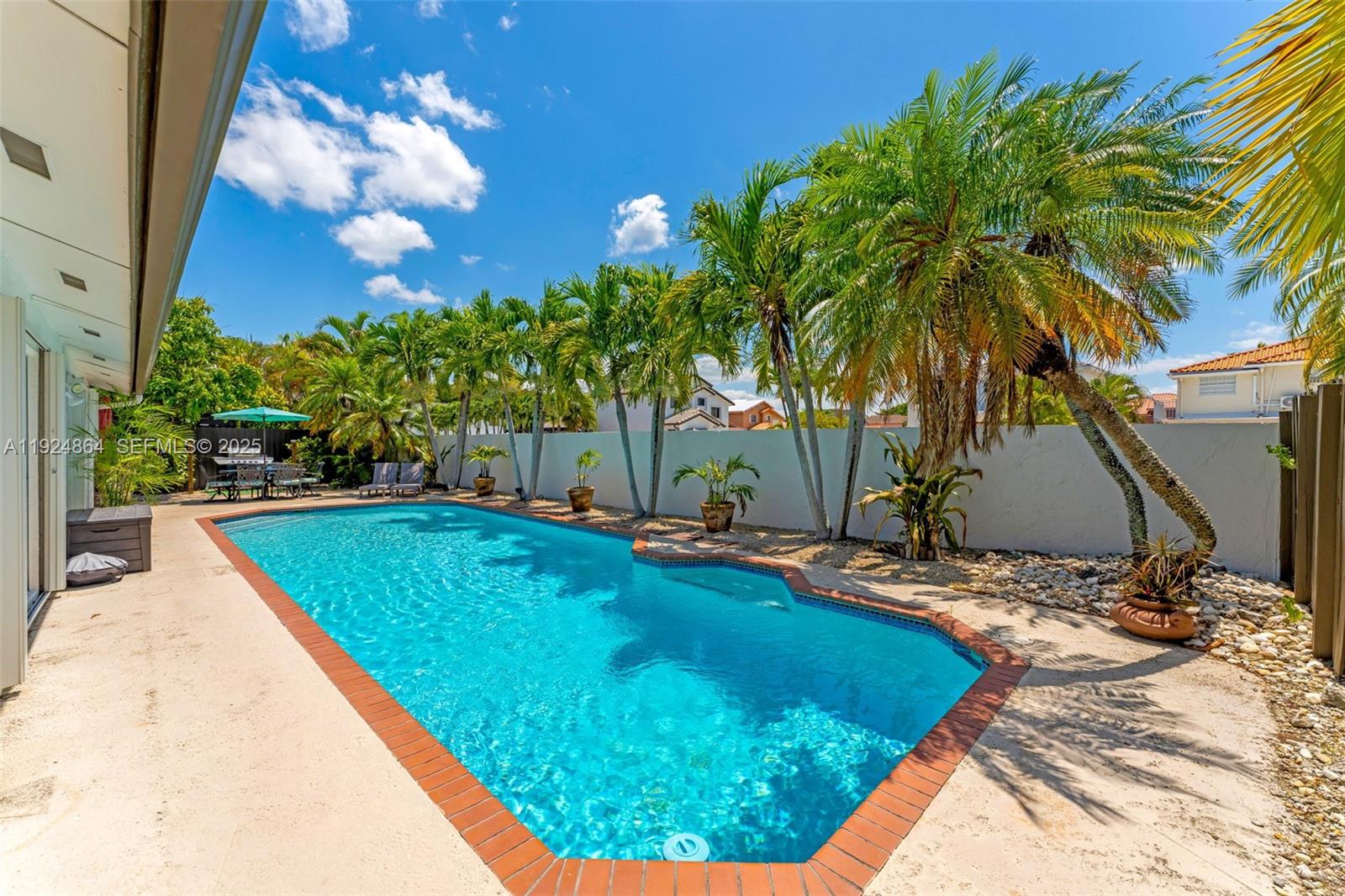 10020 Southwest 145th Place Miami, FL 33186 - Photo 12 of 35 a view of a swimming pool with an outdoor space and seating area