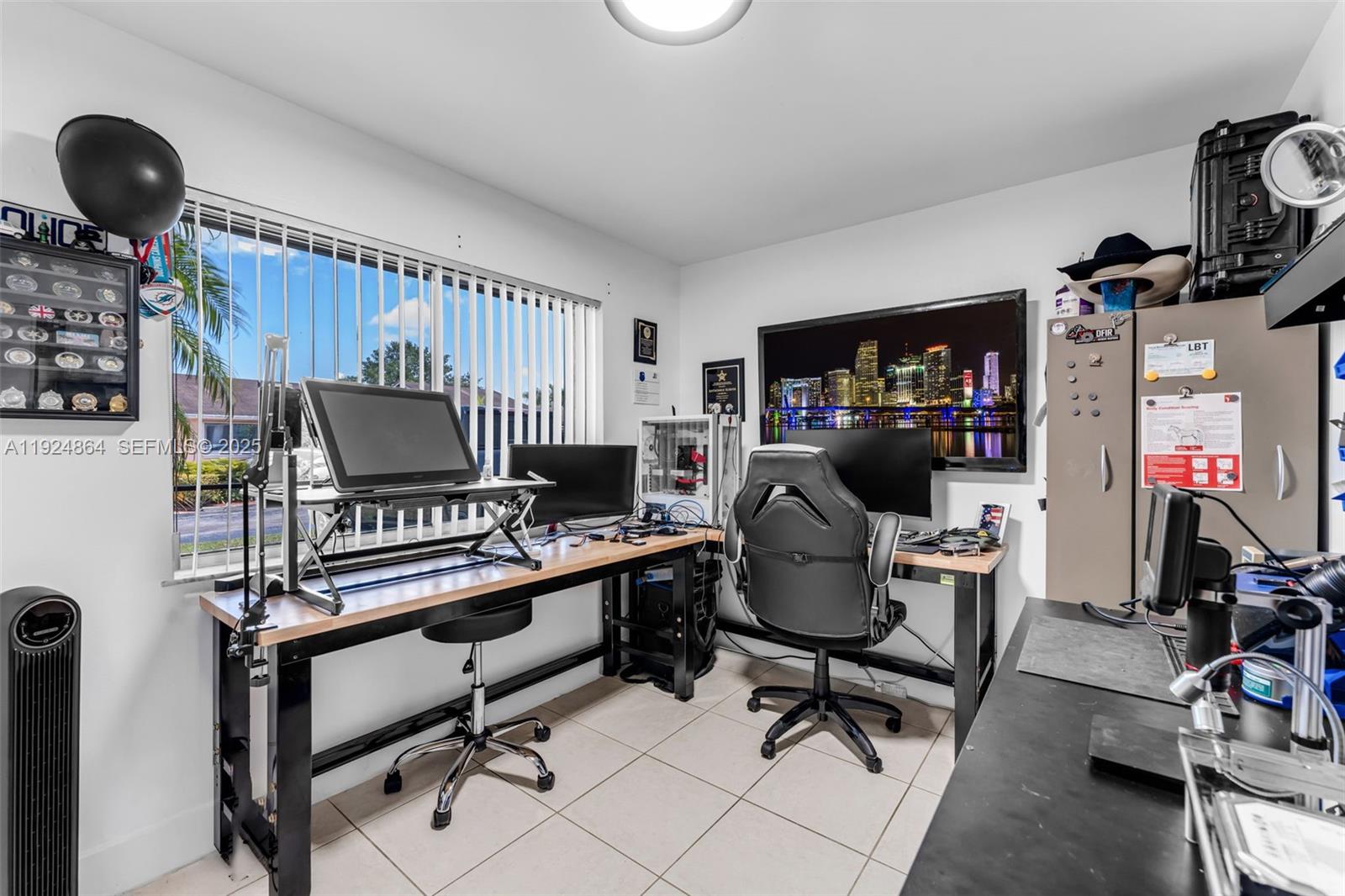 10020 Southwest 145th Place Miami, FL 33186 - Photo 23 of 35 a work room with furniture and a flat screen tv