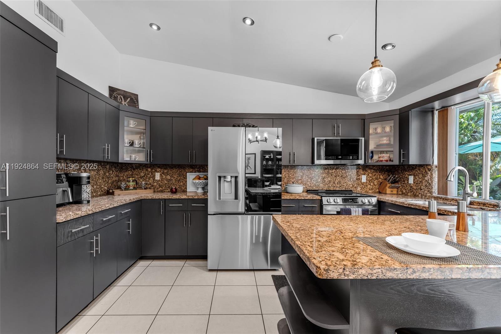 10020 Southwest 145th Place Miami, FL 33186 - Photo 28 of 35 a kitchen with stainless steel appliances granite countertop a sink counter space cabinets and a stove