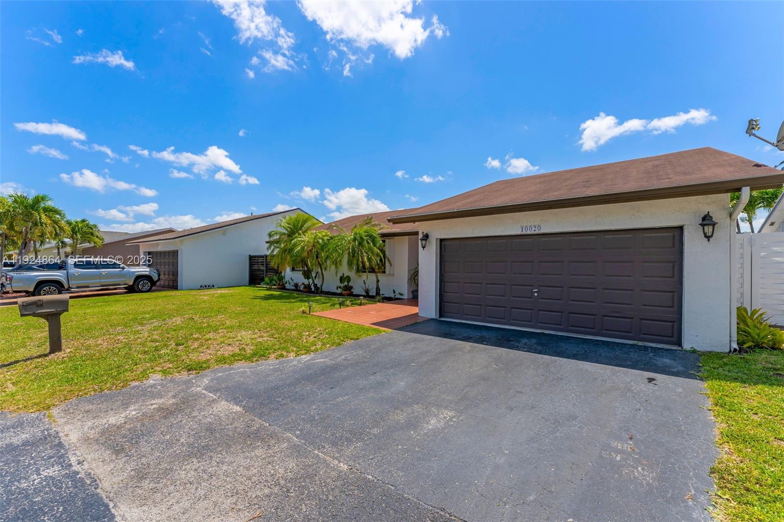 10020 Southwest 145th Place Miami, FL 33186 - Photo 34 of 35 a front view of a house with garage and yard