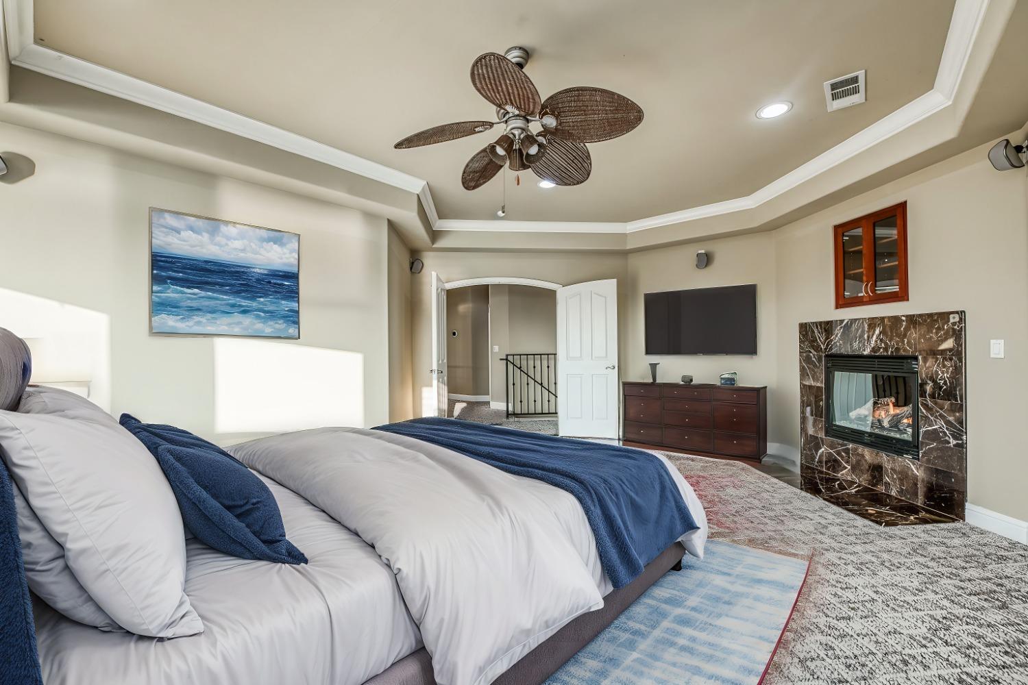 4679 North Island View Clovis, CA 93619 - Photo 23 of 55 a spacious bedroom with a bed and a flat screen tv