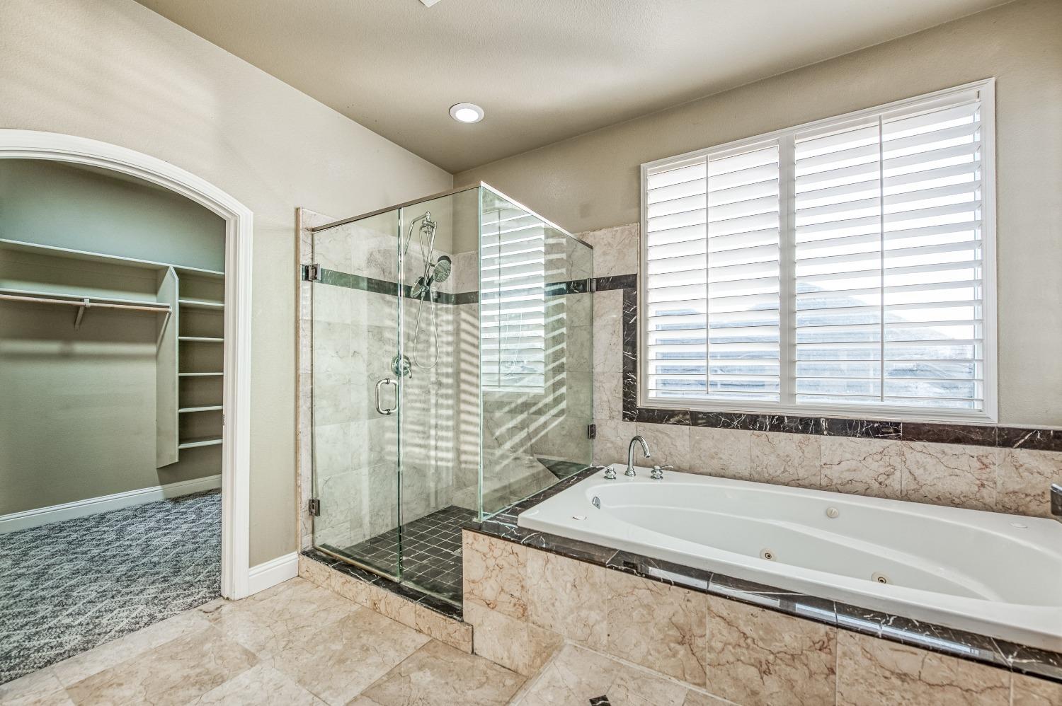 4679 North Island View Clovis, CA 93619 - Photo 25 of 55 a bathroom with a bathtub and shower