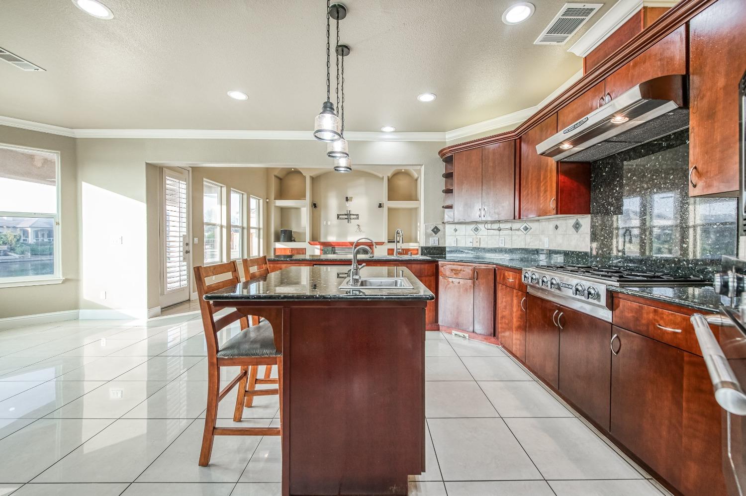 4679 North Island View Clovis, CA 93619 - Photo 8 of 55 a large kitchen with stainless steel appliances granite countertop a stove and a view of living room