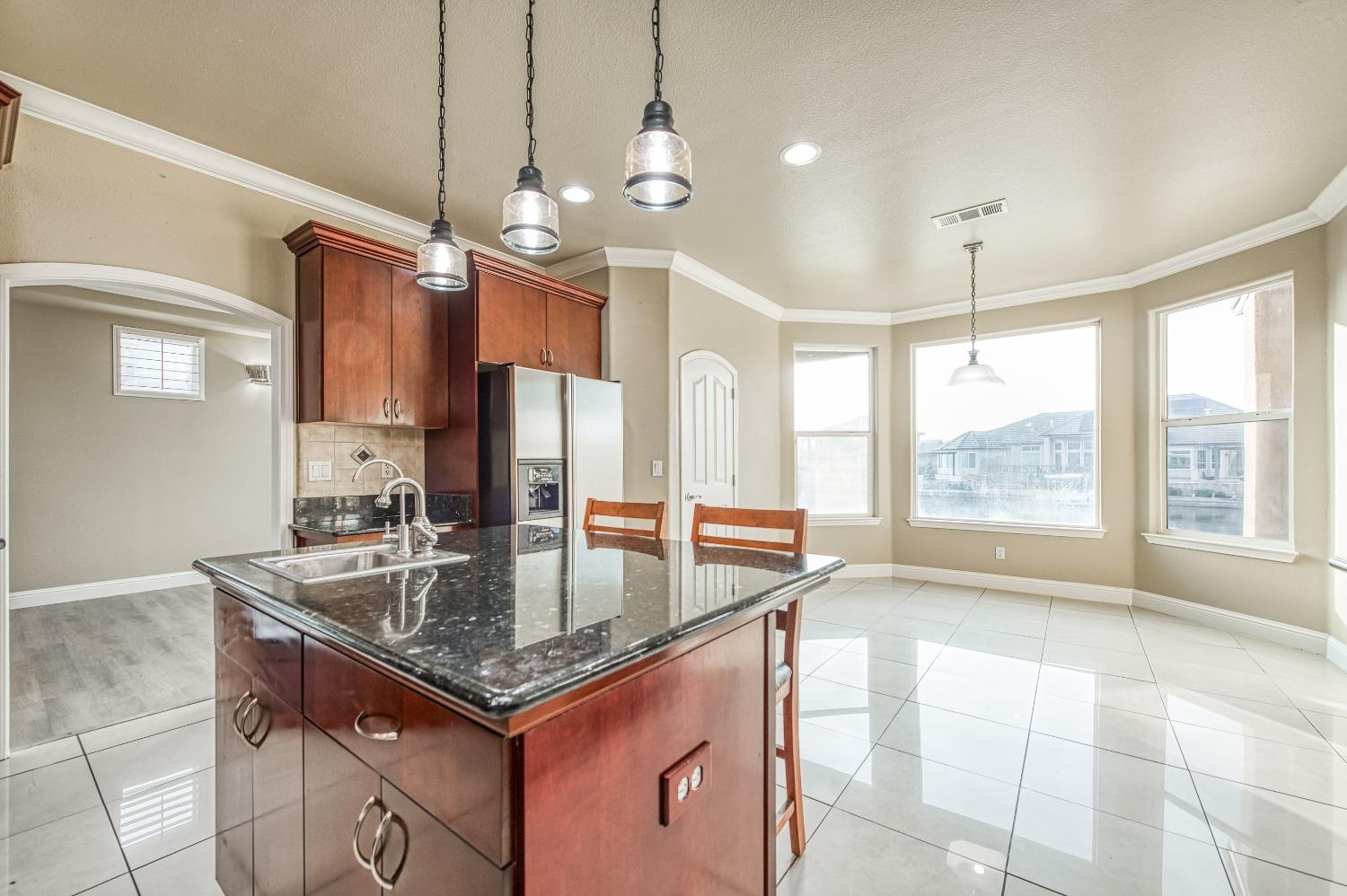 4679 North Island View Clovis, CA 93619 - Photo 10 of 55 a kitchen with granite countertop a sink a counter top space appliances and cabinets