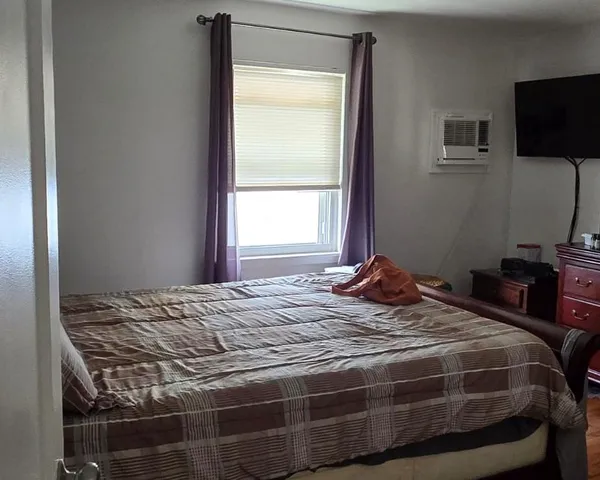 a bedroom with a bed and a flat screen tv