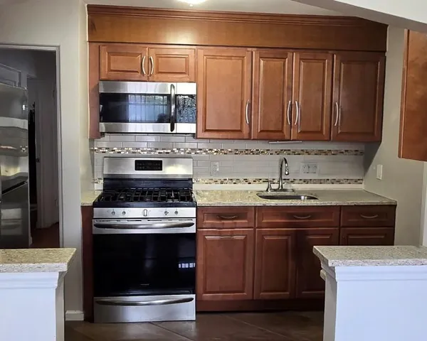 a kitchen with stainless steel appliances granite countertop a stove and a microwave