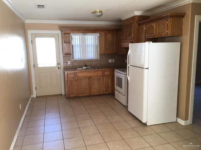 1504 East Quail Street Pharr, TX 78577 - Photo 3 of 12 a kitchen with a refrigerator a stove top oven and cabinets