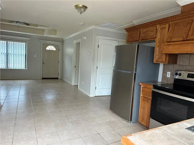 a kitchen with stainless steel appliances granite countertop a refrigerator and a stove