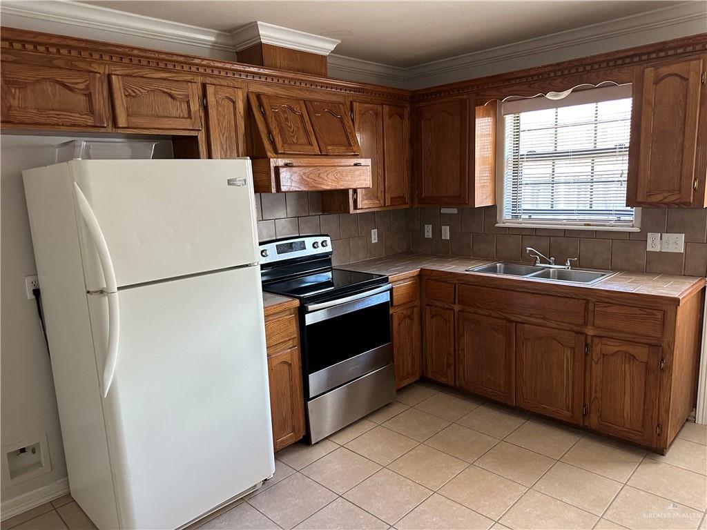 1504 East Quail Street Pharr, TX 78577 - Photo 5 of 12 a kitchen with stainless steel appliances granite countertop a refrigerator a sink a stove a microwave and cabinets