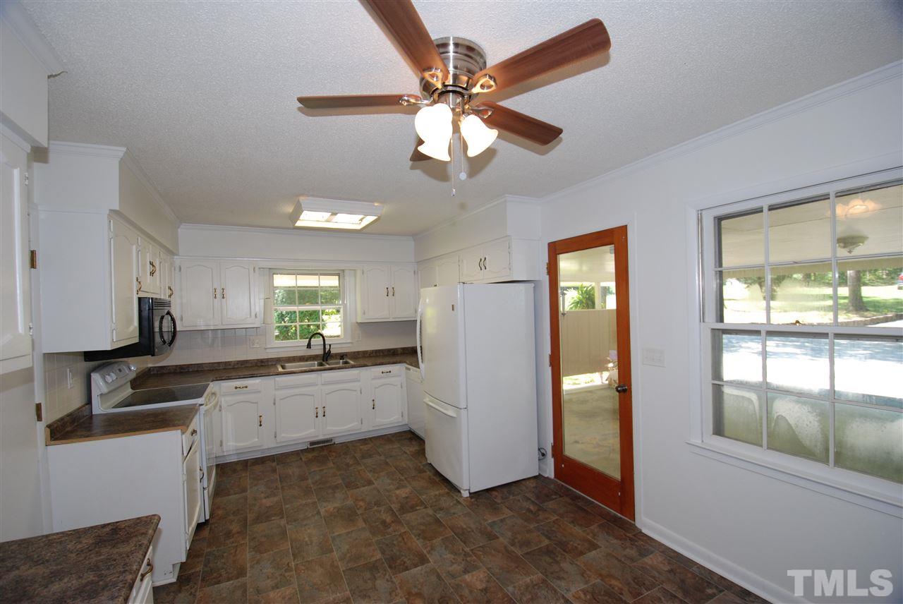 6908 Lake Wheeler Road Raleigh, NC 27603 - Photo 12 of 25 a kitchen with granite countertop a refrigerator a sink a stove a dining table and chairs