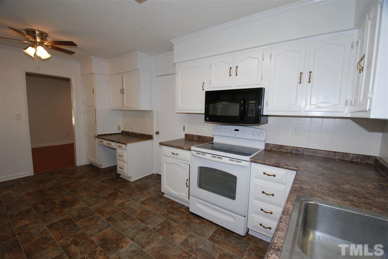 6908 Lake Wheeler Road Raleigh, NC 27603 - Photo 13 of 25 a kitchen with granite countertop a stove sink and cabinets