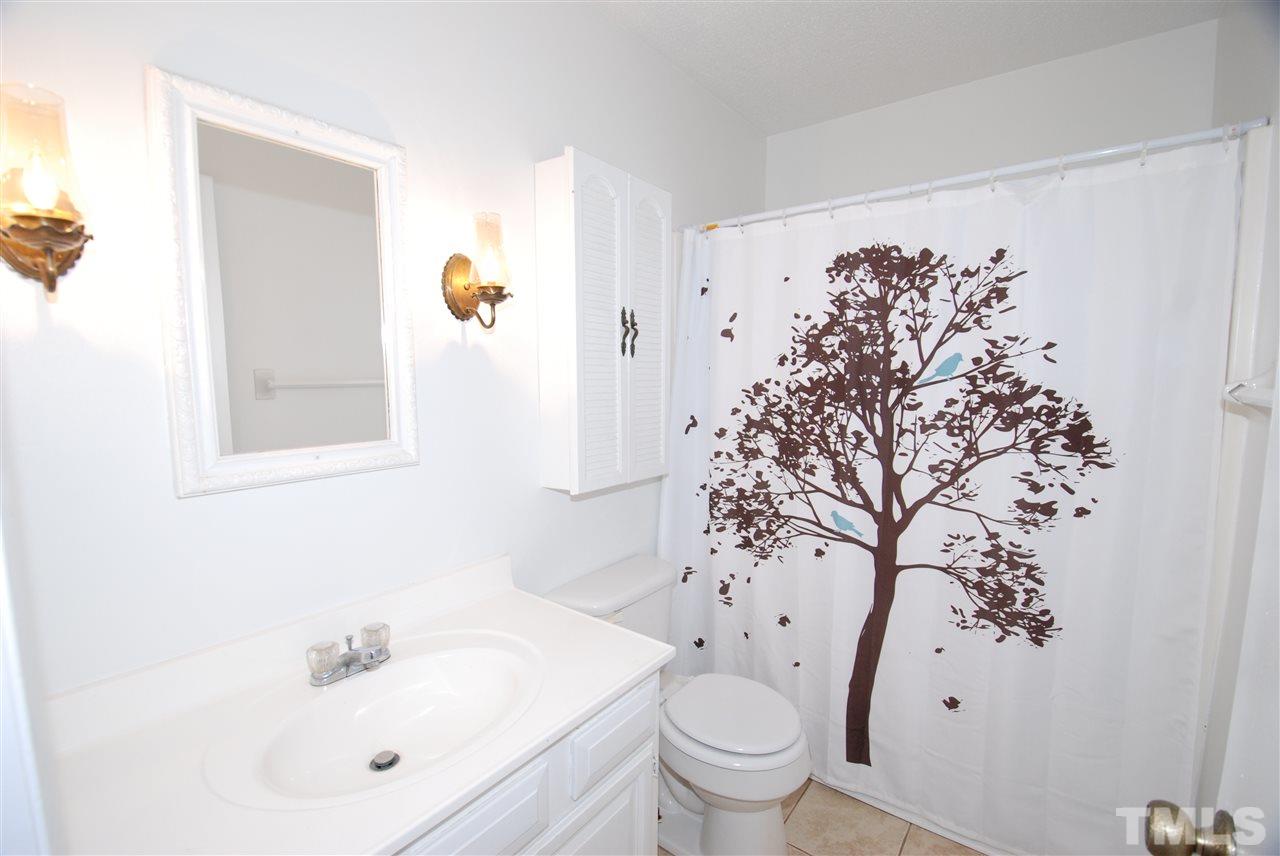 6908 Lake Wheeler Road Raleigh, NC 27603 - Photo 16 of 25 a bathroom with a sink and mirror with toilet