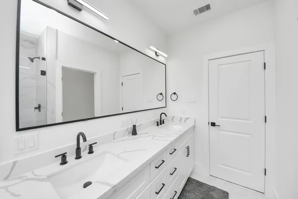 a bathroom with double vanity sink and mirror