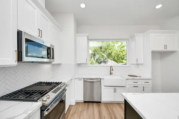 a kitchen with a stove a sink and a microwave