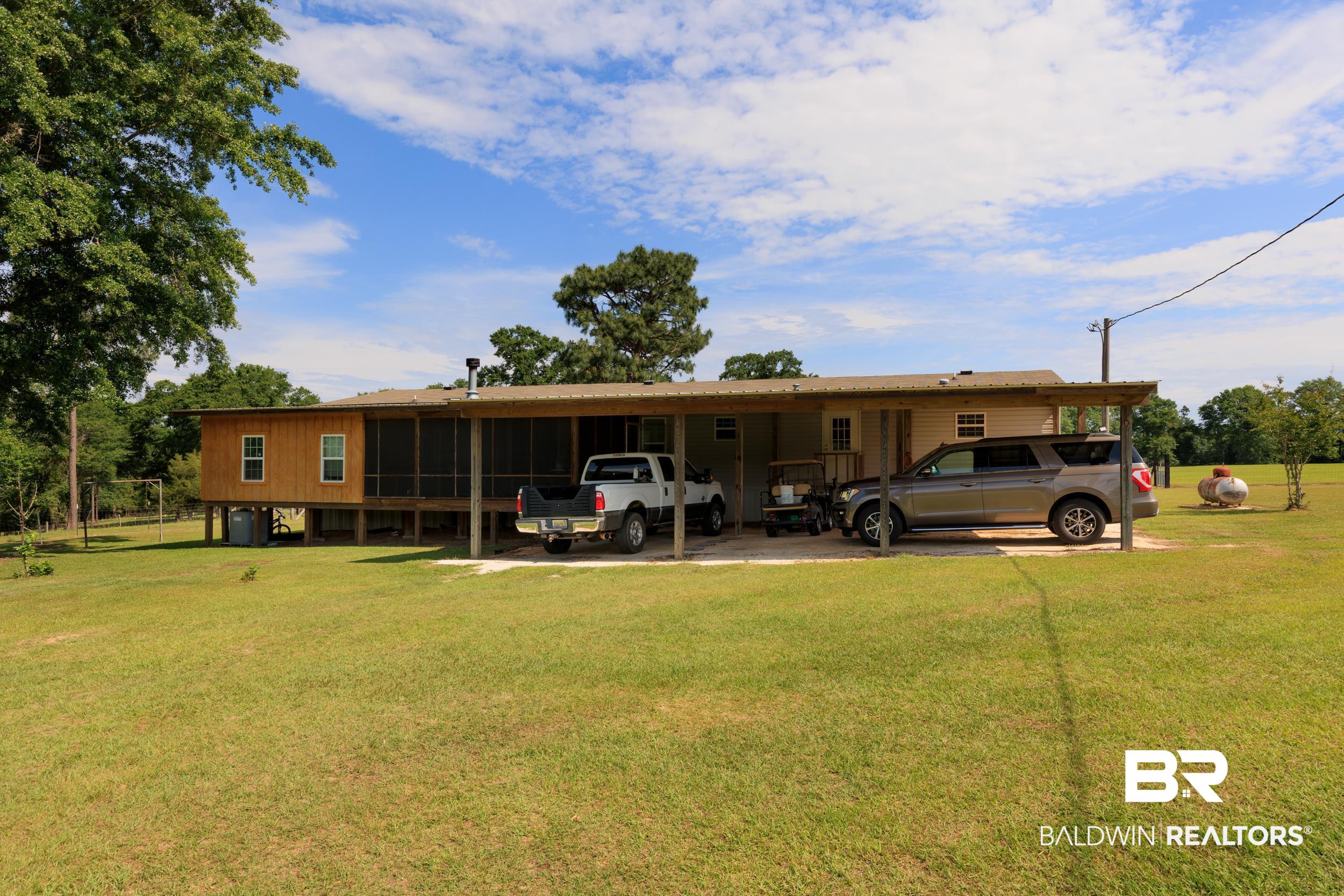 6725 Upper Creek Road Flomaton, AL 36441 - Photo 17 of 61 Rear view of property with a carport and a lawn