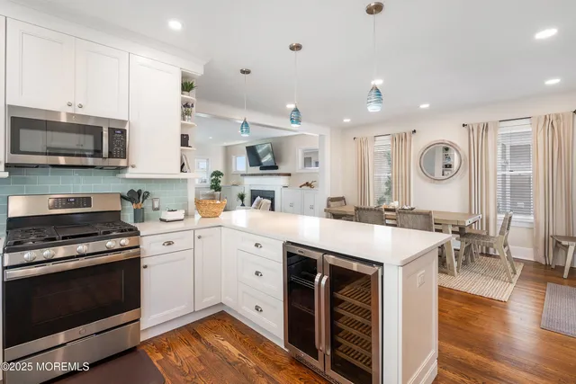 a large room with lots of white furniture and a wooden floor