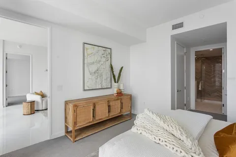a bedroom with a bed and white wall painting