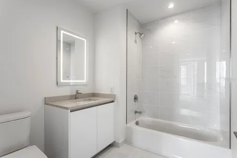 a bathroom with a granite countertop sink a toilet and shower