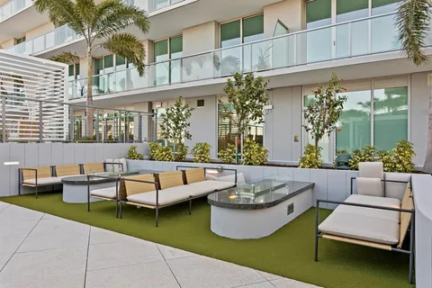 a view of a patio with couches table and chairs and potted plants