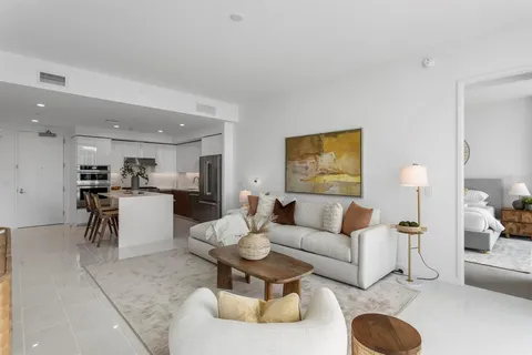 a living room with furniture and kitchen view