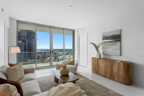 a living room with furniture and a floor to ceiling window