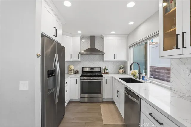 a kitchen with stainless steel appliances a refrigerator stove and white cabinets