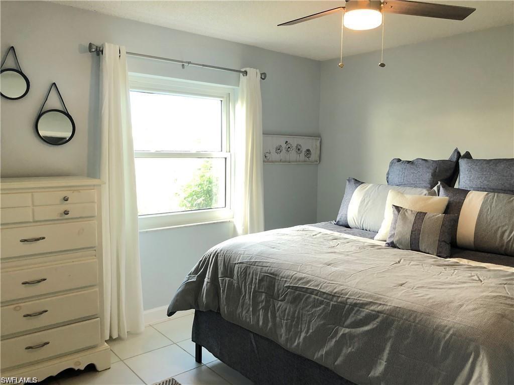 1000 Manatee Road, Unit A105 Naples, FL 34114 - Photo 4 of 22 a bedroom with a bed and window