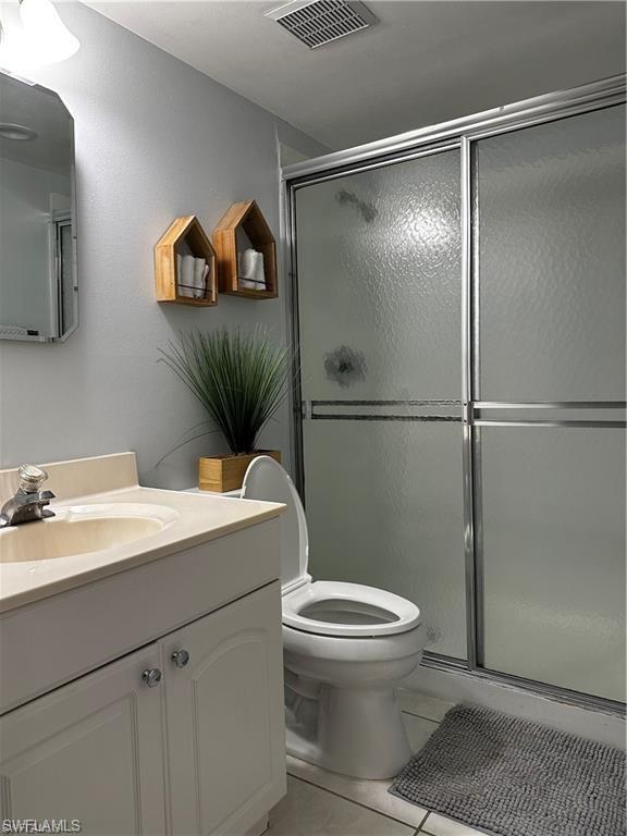 1000 Manatee Road, Unit A105 Naples, FL 34114 - Photo 7 of 22 a bathroom with a granite countertop sink mirror vanity and toilet