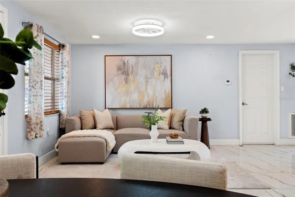 a living room with furniture and a potted plant